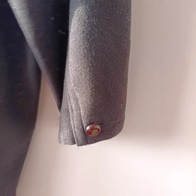 Trenca con capucha negra, fabricada en España.