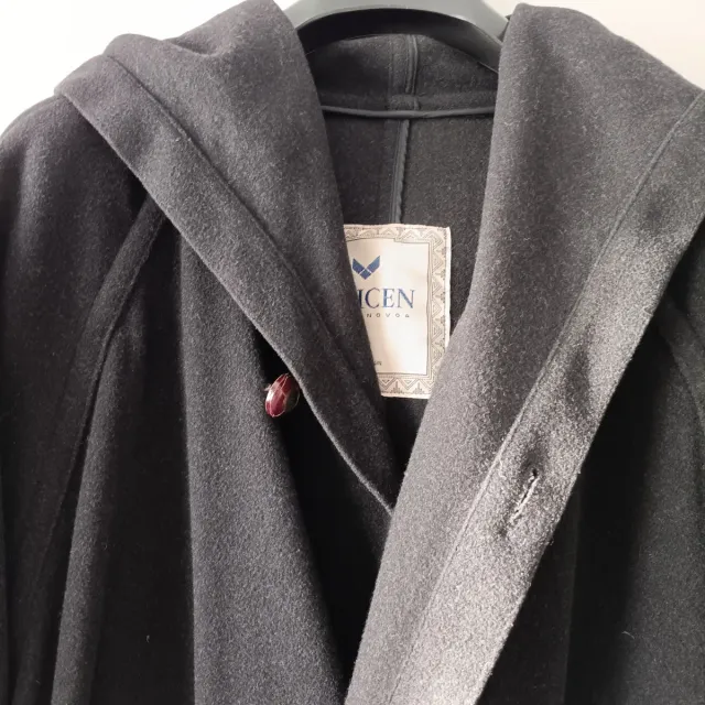 Trenca con capucha negra, fabricada en España.