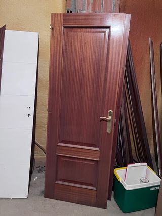 Puerta de madera oscura con manilla dorada