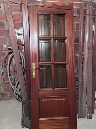 Puerta de madera oscura con manilla dorada