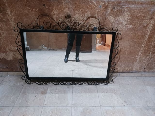 Espejo con marco decorativo de volutas