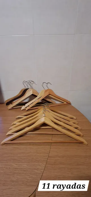 11 Perchas con barra rayada, cinco con funda.