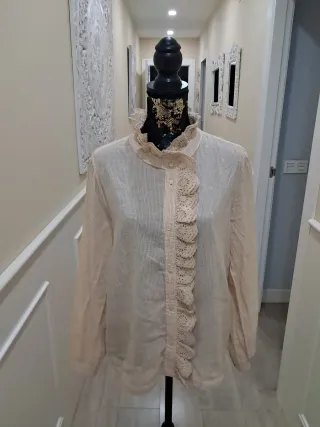 Blusa beige con volantes y cuello alto