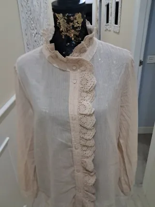 Blusa beige con volantes y cuello alto