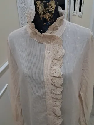 Blusa beige con volantes y cuello alto