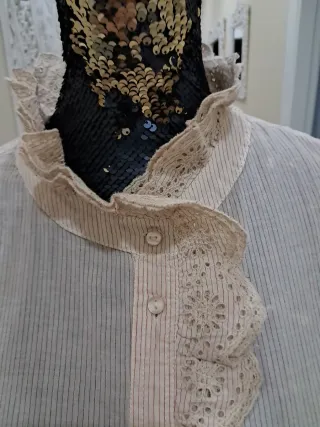 Blusa beige con volantes y cuello alto