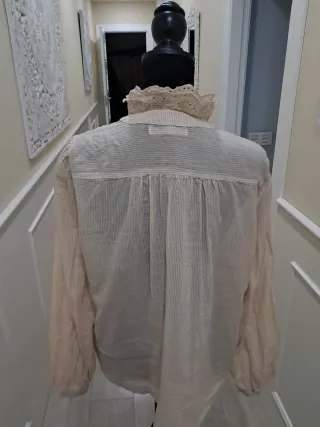 Blusa beige con volantes y cuello alto