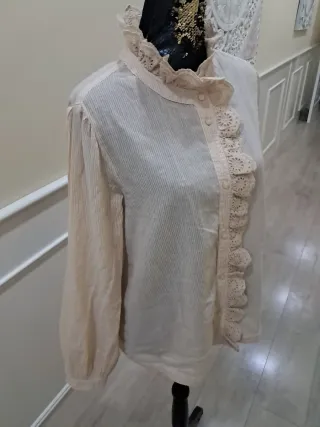 Blusa beige con volantes y cuello alto