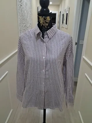 Blusa beige con volantes y cuello alto