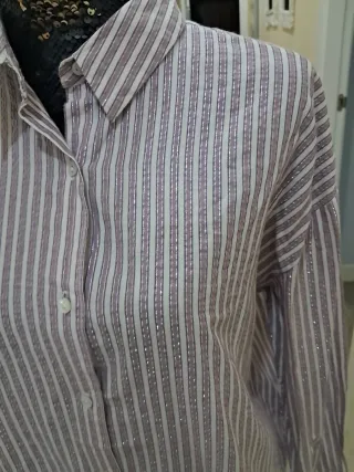 Blusa beige con volantes y cuello alto