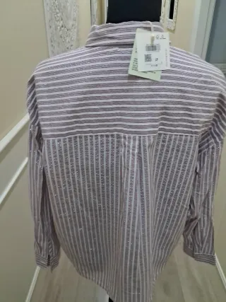 Blusa beige con volantes y cuello alto