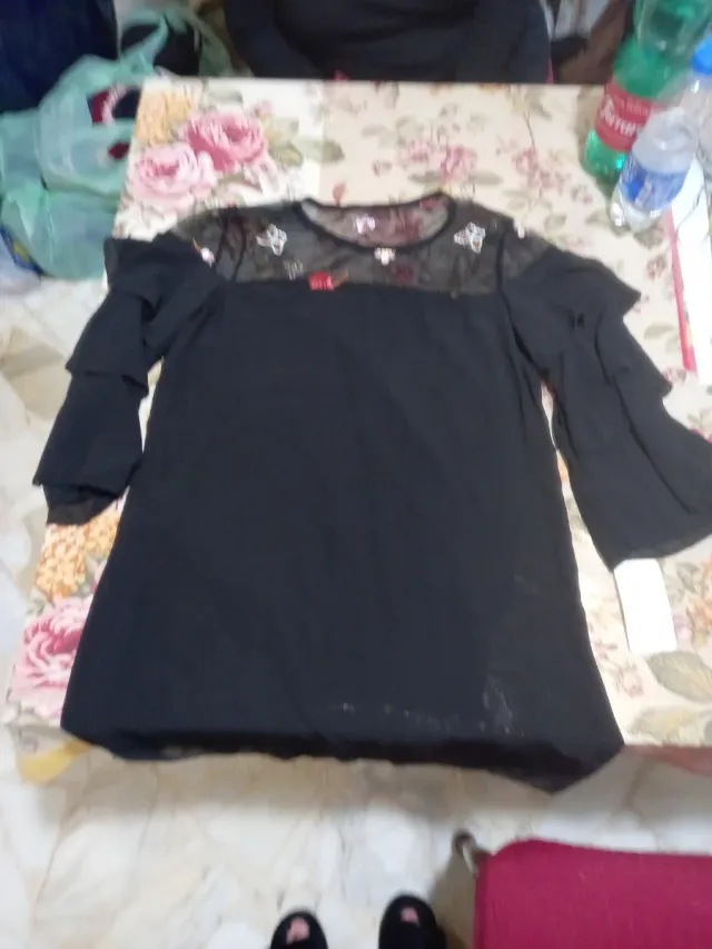 Maglia nera donna con pizzo ricamato di fiori.