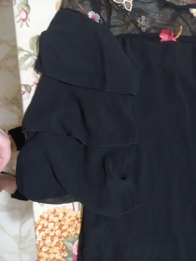 Maglia nera donna con pizzo ricamato di fiori.