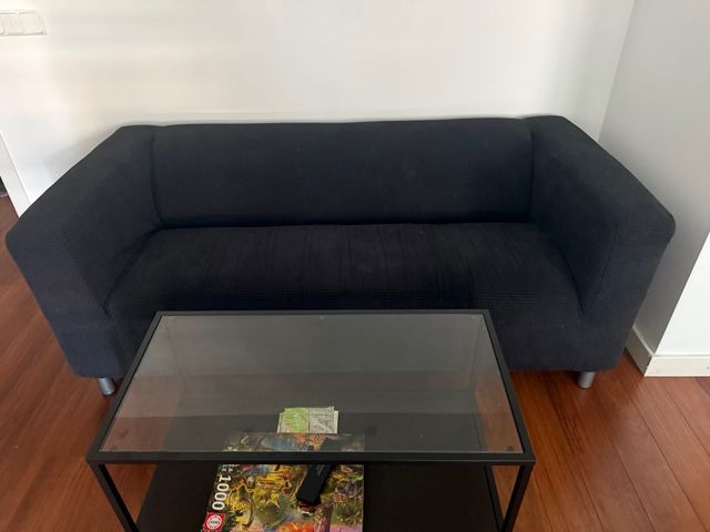 Sofá negro con mesa de centro de cristal