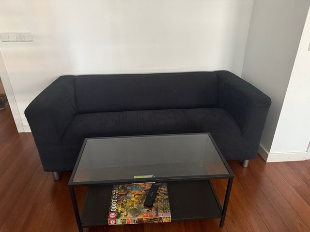 Sofá negro con mesa de centro de cristal