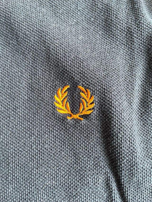 Polo Fred Perry azul con detalles naranja