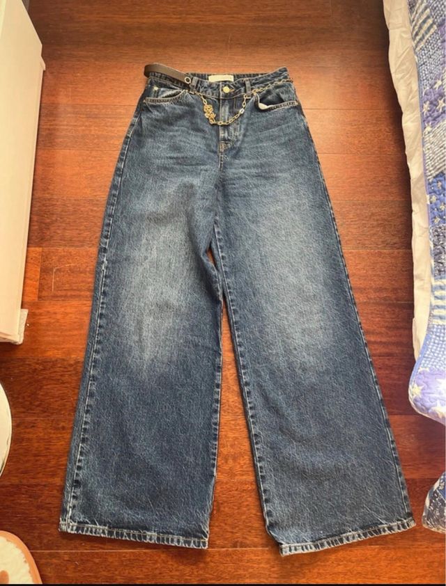 Pantalón vaquero azul con cinturón cadena dorada