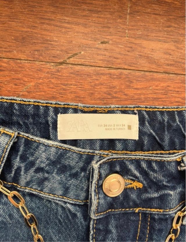 Pantalón vaquero azul con cinturón cadena dorada