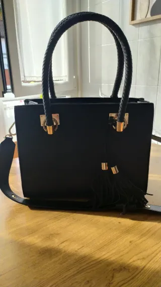 Bolso negro con flecos y asa trenzada