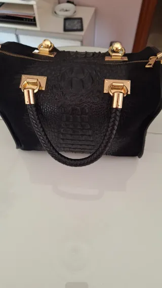 Bolso de piel negro con detalles dorados