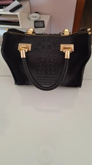 Bolso de piel negro con detalles dorados