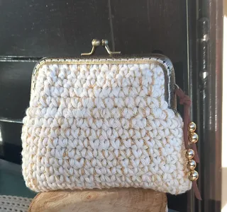 Monedero tejido a mano con detalles dorados