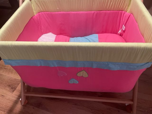 Cuna de bebé rosa y amarilla