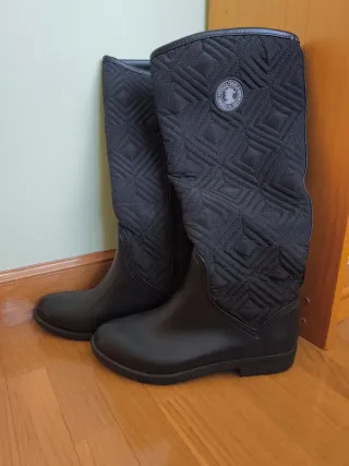 Botas altas negras planas.