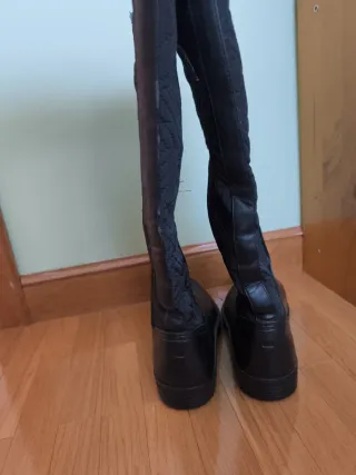 Botas altas negras planas.