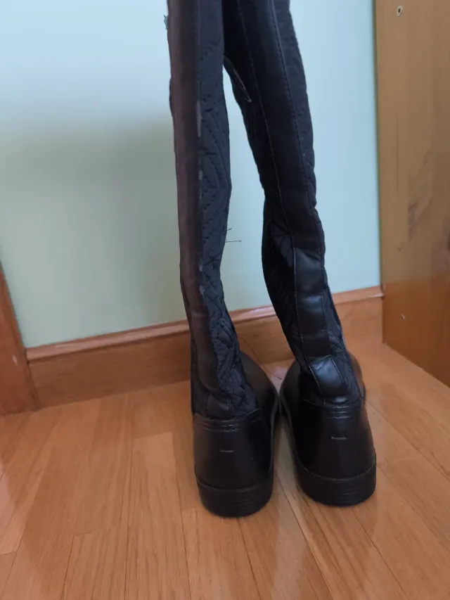 Botas altas negras planas.