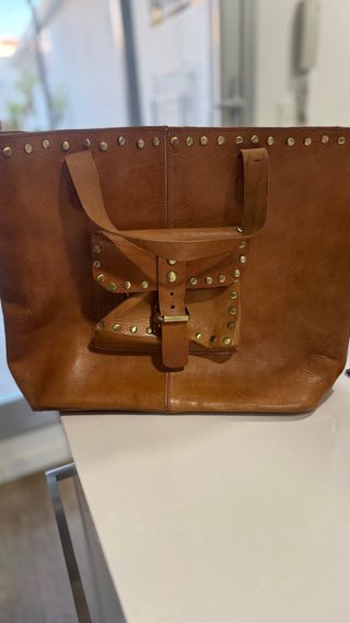 Bolso de cuero marrón con tachuelas
