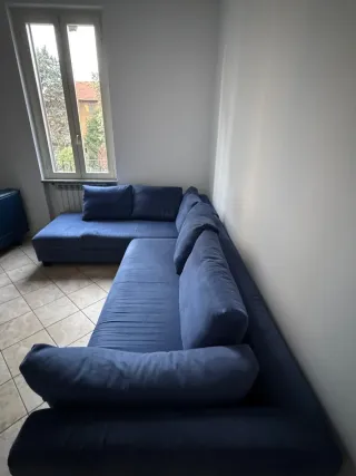 Divano angolare in tessuto blu.