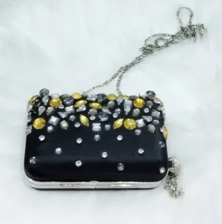 Bolso clutch apliques metálicos. Chesco.