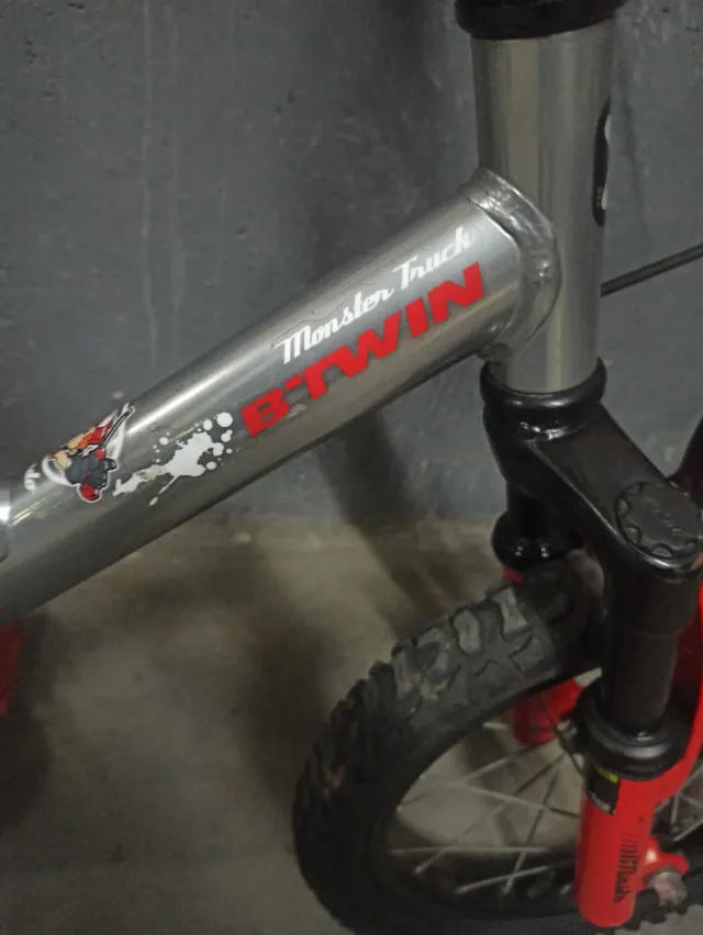 Bicicleta infantil plateada con detalles rojos