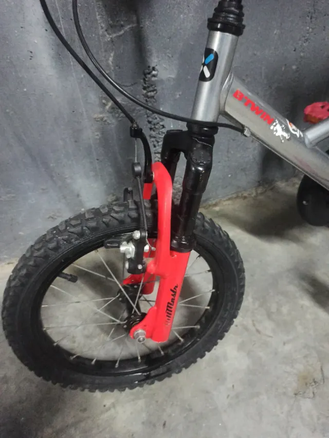 Bicicleta infantil plateada con detalles rojos