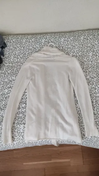 Chaqueta larga de lana beige con cinturón.