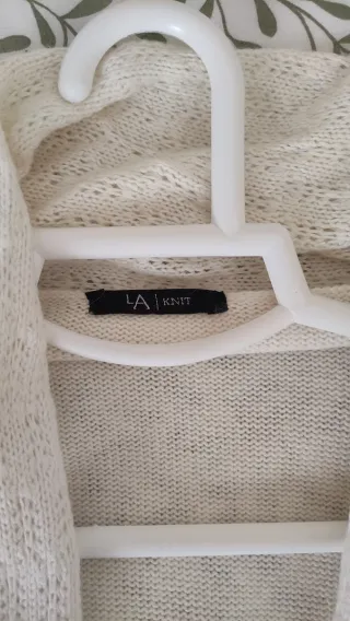 Chaqueta larga de lana beige con cinturón.