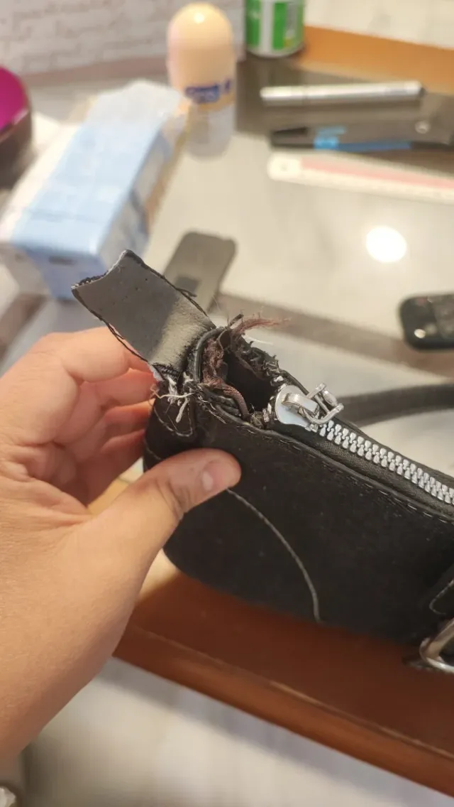 Bolso negro con cadena plateada, descosido