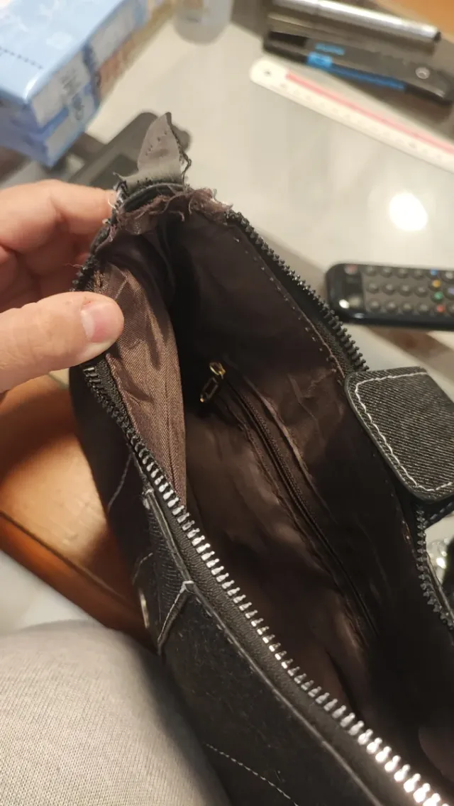 Bolso negro con cadena plateada, descosido