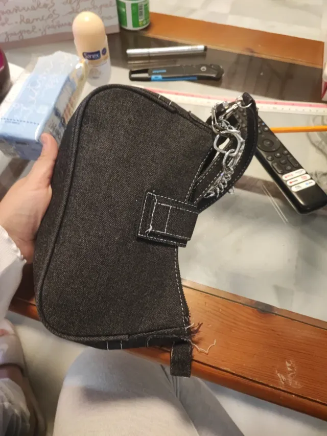 Bolso negro con cadena plateada, descosido