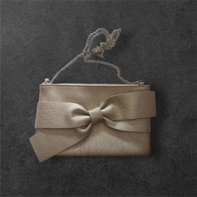 Bolso dorado con lazo y cadena