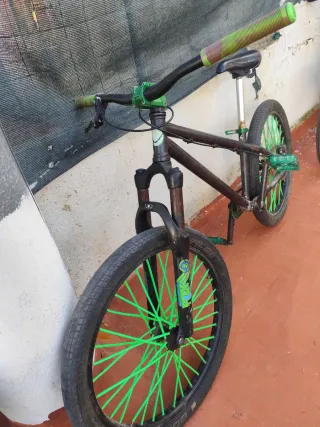 Bicicleta Dirt Jump nera con ruote verdi