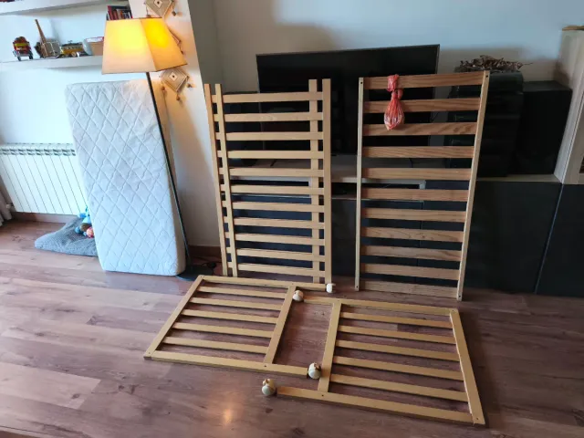 Cuna de madera con colchón y ropa de cama.