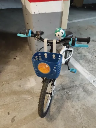 Bici infantil blanca con cesta y timbre.