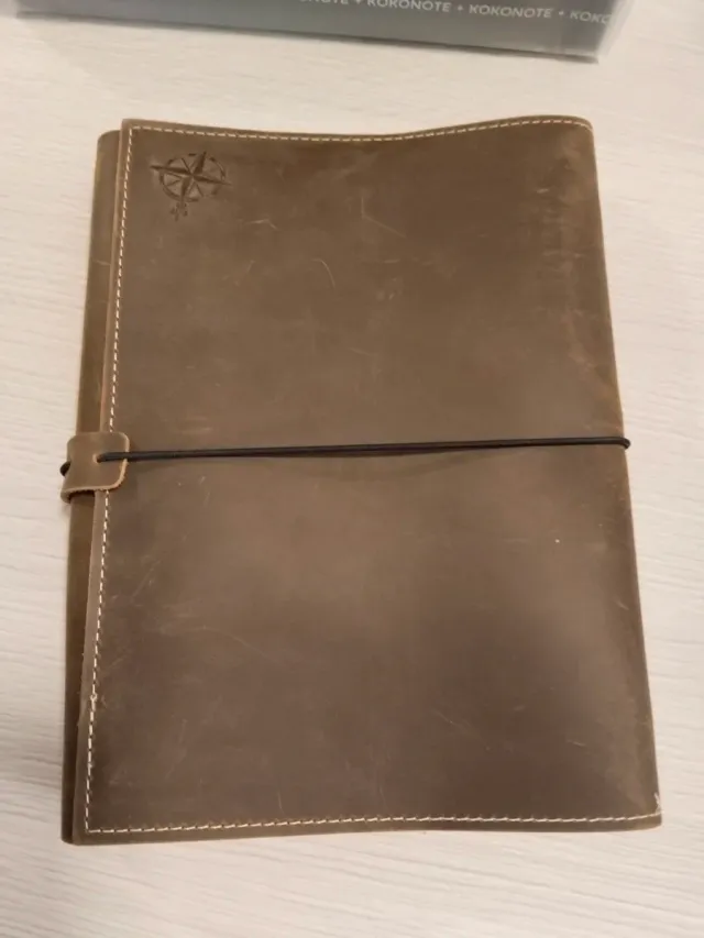 Caderno de couro com bússola e elástico
