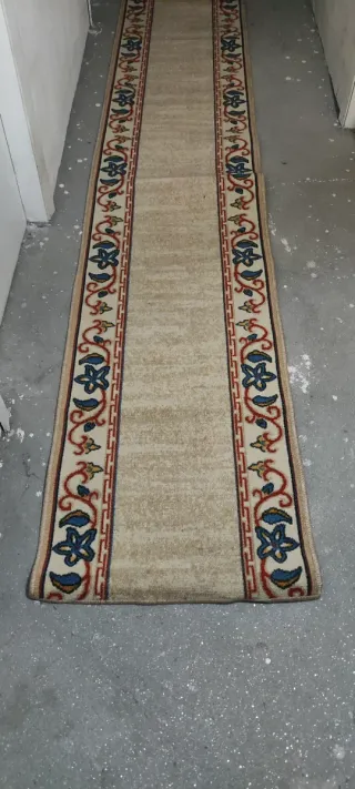 Alfombra de pasillo beige con diseño floral