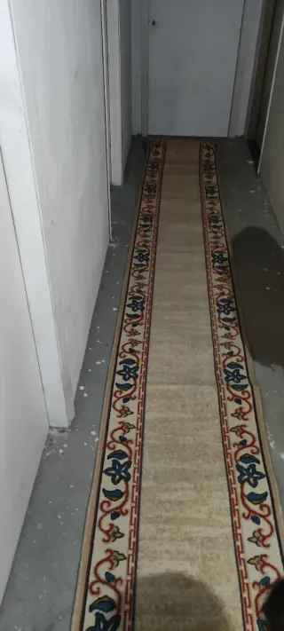 Alfombra de pasillo beige con diseño floral