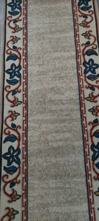 Alfombra de pasillo beige con diseño floral