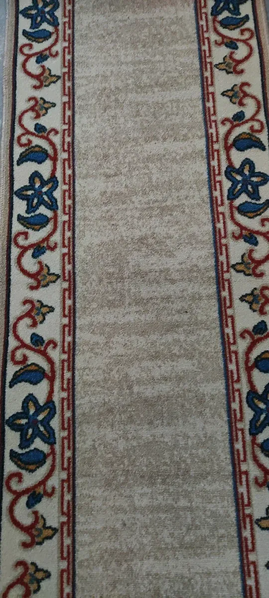 Alfombra de pasillo beige con diseño floral