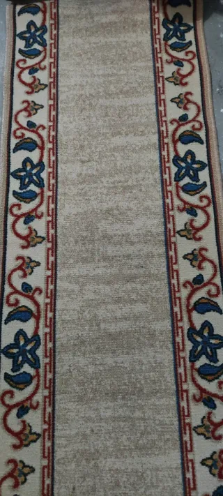 Alfombra de pasillo beige con diseño floral